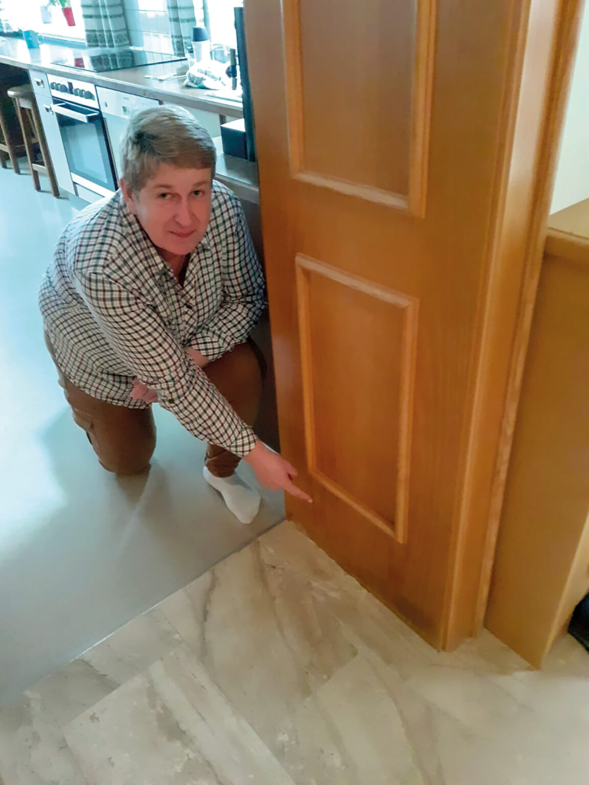 Frau Grenl zeigt auf die Höhe des Hochwassers von 2002 anhand des Türstockes, wo nur ein minimaler Schaden zurückblieb. Der Türstock musste nicht ausgetauscht werden.